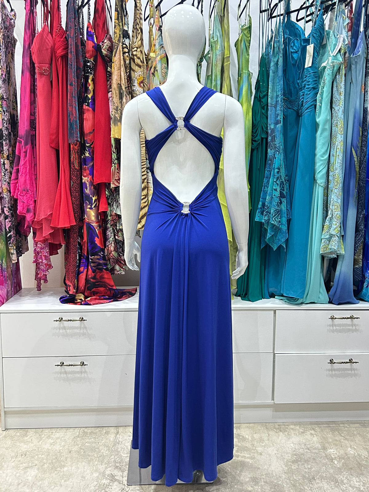 A striking royal blue sleeveless maxi dress with a sweetheart neckline and a ruched bodice held together by a metal ring decorated in Swarovski crystals.